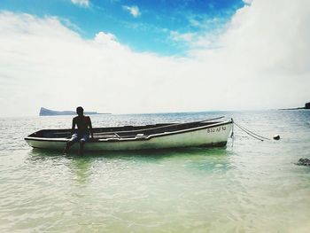 Man in boat on sea against sky