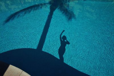 High angle view of person shadow swimming in pool