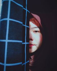 Close-up portrait of young woman against black background