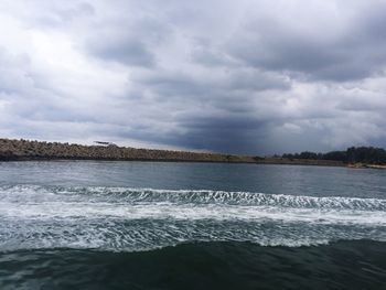 View of seascape against cloudy sky