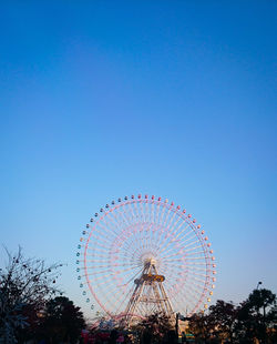 Low angle view of ferris wheel against clear sky