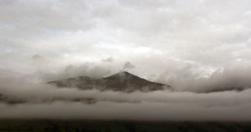 Scenic view of mountains against cloudy sky