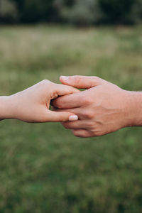 Close-up of couple holding hands outdoors