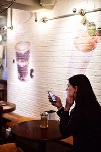 Young woman using smart phone on table