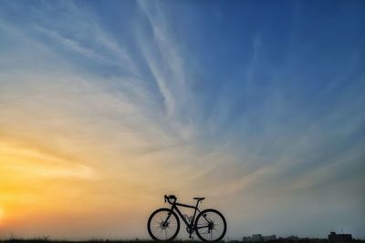Low angle view of silhouette bicycle against sky during sunset