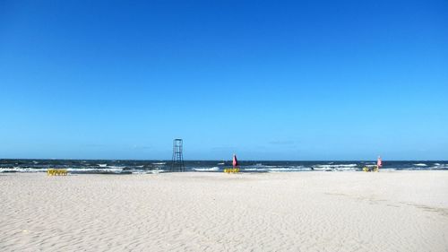 Scenic view of beach against clear blue sky