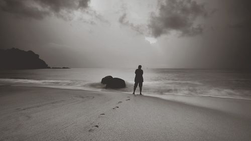 Men on beach against sky