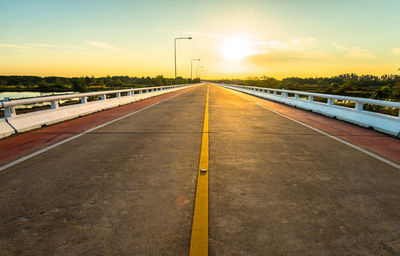 Surface level of road against sky during sunset