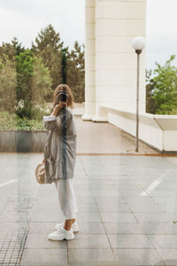 Rear view of woman walking on footpath