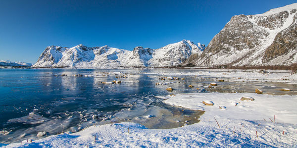 Scenic view of snowcapped mountains against blue sky