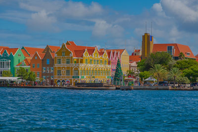 Buildings in city against cloudy sky