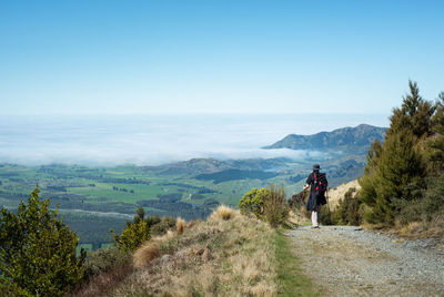 Rear view of people on mountain against sky