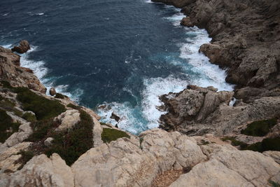 High angle view of rocks on sea shore