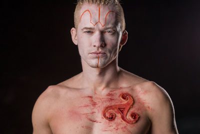 Portrait of young man against black background