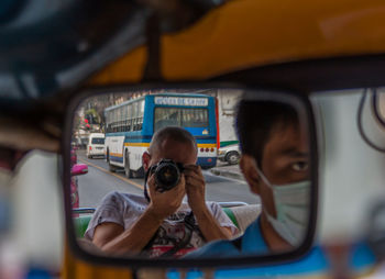 Portrait of boy with camera in bus