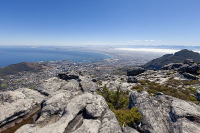 Scenic view of sea and mountains against blue sky