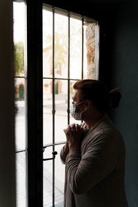 Side view of a man drinking glass window