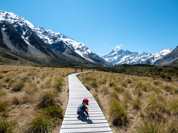 Woman on snowcapped mountain against sky