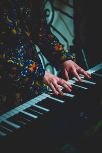 Midsection of woman playing piano