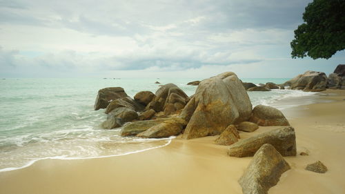 Rocks on beach against sky