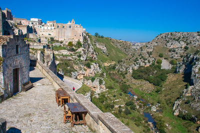 Ancient stone house with grapes tree and old wooden tables and chairs overlooking the canyon