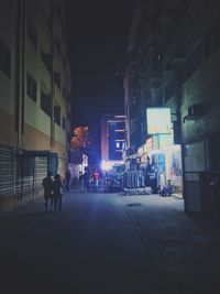 People in illuminated city at night