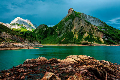 Scenic view of lake by mountains against sky