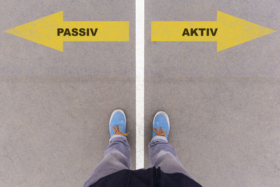 Low section of man standing on road