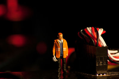 Midsection of man standing on table against dark background