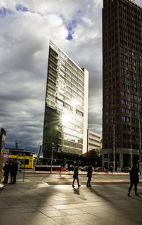 People in city against cloudy sky