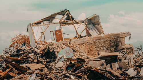 Abandoned house on field against sky