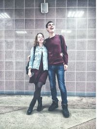 Portrait of young couple standing against wall