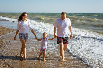Happy family walking by the sea