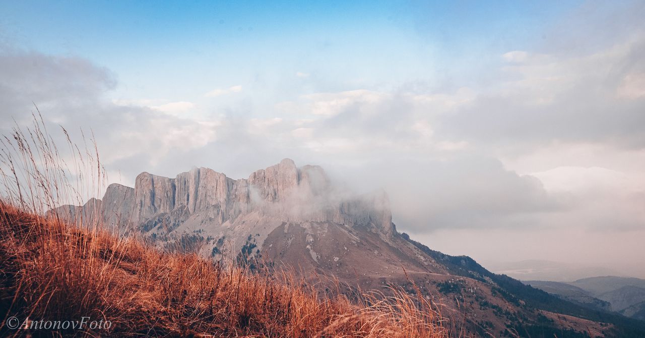 PANORAMIC VIEW OF MOUNTAIN RANGE AGAINST SKY