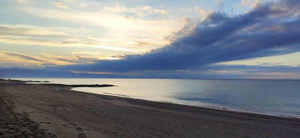 Scenic view of beach against sky during sunset