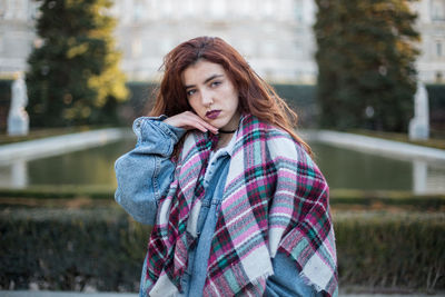 Portrait of woman in warm clothes while standing in city during winter