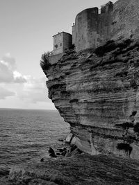 Sea shore by buildings against sky