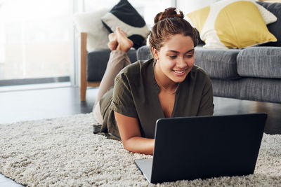 Young woman using mobile phone at home