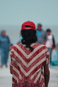 Rear view of person sitting at beach