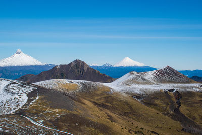 Scenic view of snowcapped mountains against blue sky