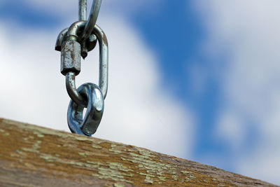 Low angle view of chain against sky