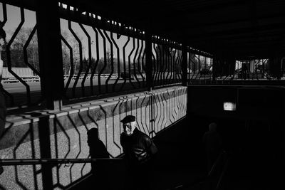 Rear view of men standing on railing in city