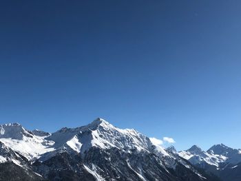 Scenic view of snowcapped mountains against clear blue sky