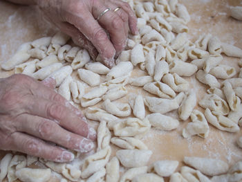 Cropped hands making pasta on wooden table