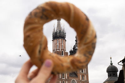 Tourist woman eating bagel obwarzanek traditional polish cuisine snack waling on market square st