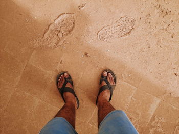 Low section of man standing on dusty floor