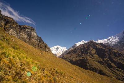 Scenic view of snowcapped mountains against blue sky