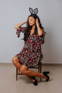 Portrait of young woman against wall