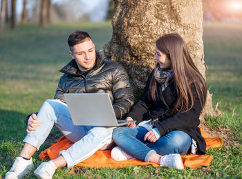 Portrait of woman using laptop while sitting at park