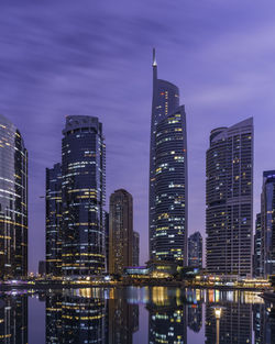Illuminated buildings against sky at night